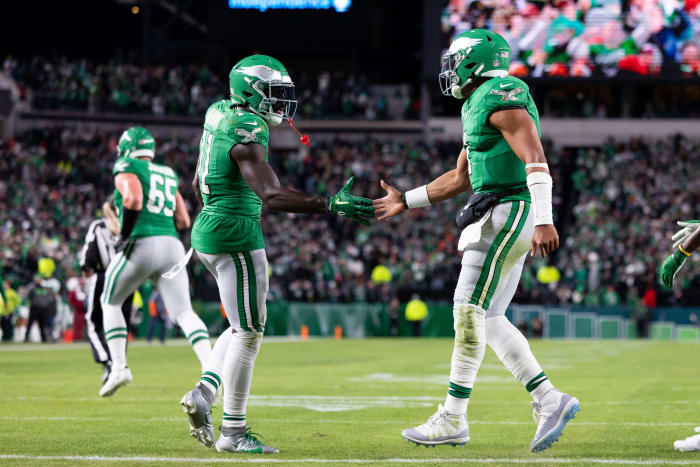 A.J. Brown and Jalen Hurts shake hands wearing kelly green jerseys